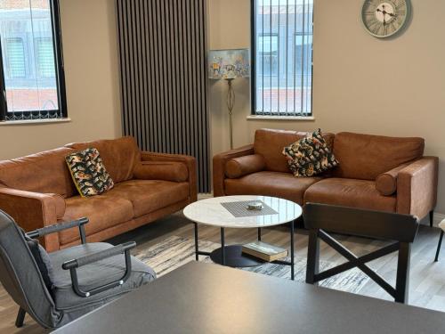 a living room with two couches and a table at London Heathrow Apartment - West Drayton in Yiewsley