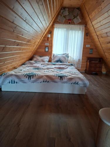 a bedroom with a bed in a wooden cabin at A frame iris in Filioara