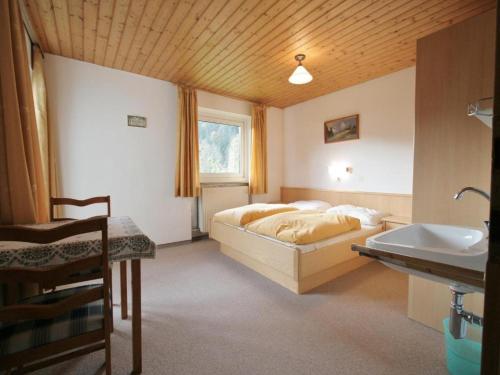 a bedroom with a bed and a sink at Chalet Gamper by Summit Travel in Ellmau