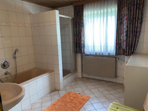a bathroom with a bath tub and a sink at Chalet Gamper by Summit Travel in Ellmau