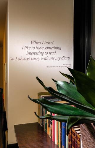 a sign on a wall with a book shelf with books at Phi Hotel Bologna in Bologna