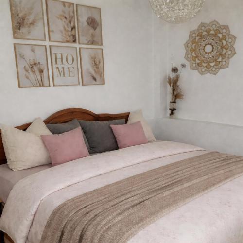 ein Schlafzimmer mit einem Bett mit rosa und grauen Kissen in der Unterkunft Thüringer Pforte in Gorsleben