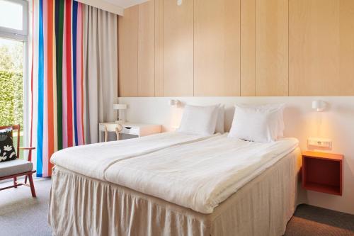 a bedroom with a large bed with white sheets at IKEA Hotell in Älmhult