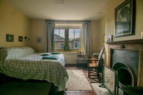 a bedroom with a bed and a fireplace and a window at The Brontë Birthplace in Thornton