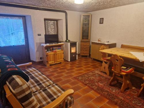 a living room with a table and a tv and a table sidx sidx at maso denis in Canale San Bovo