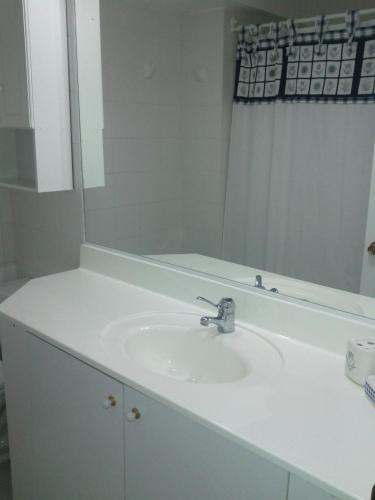 a bathroom with a white sink and a mirror at A Pasos de la Playa in Papudo