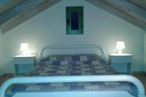 a bedroom with a bed with two lamps on it at Vegera Apartments in Vasilikiádhes