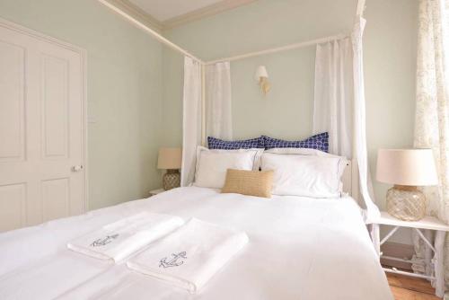 a white bed with two white towels on it at The Chocolate-Box * Aldeburgh in Aldeburgh