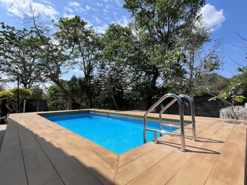 a small swimming pool with a metal hand rail next to it at Bann Kieng Kiri Khaoyai บ้านเคียงคีรี เขาใหญ่ in Mu Si