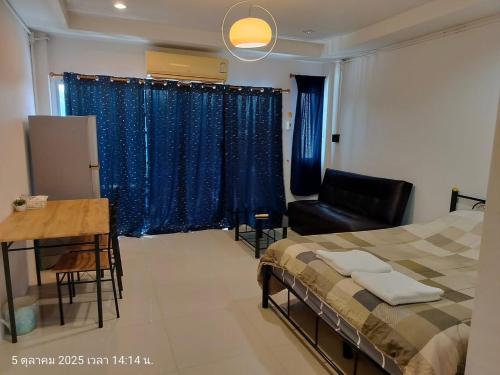 a bedroom with a bed and a desk and a chair at Pailin Daily F2 in Phetchabun