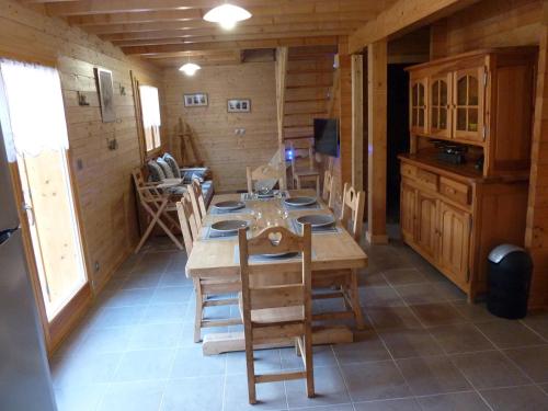 une salle à manger avec une table et des chaises dans une cabine dans l'établissement Le Planot, à La Bresse