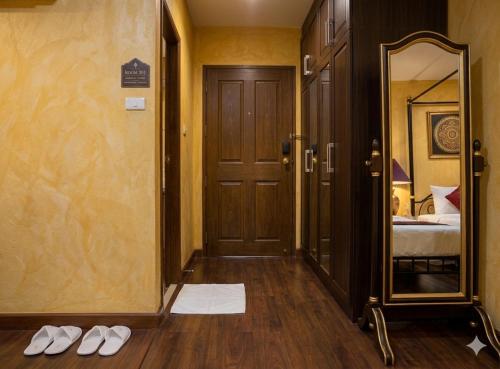 a hallway with a mirror and a pair of shoes at Chaba silom in Bang Rak