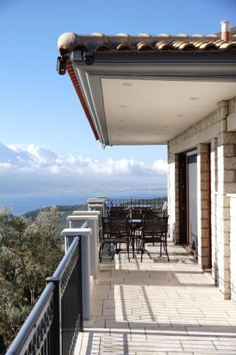 a balcony with tables and chairs on a building at Treanto Nafpaktos Boutique Hotel in Nafpaktos