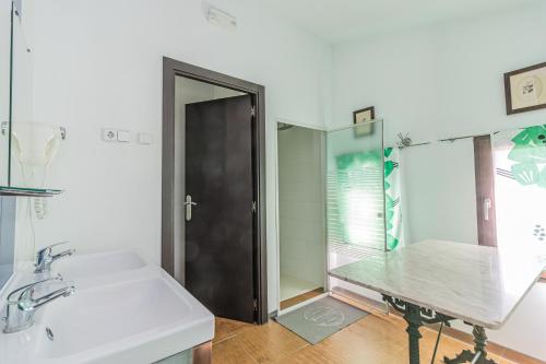 a white bathroom with a sink and a mirror at Hostel El Castillo in Aniñon