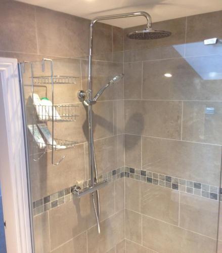 a shower with a glass door in a bathroom at Mill Cottage in Malpas