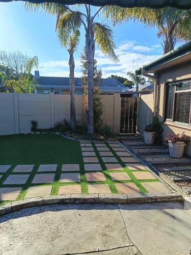 a yard with palm trees and a house at Danlavie in Tyger Valley