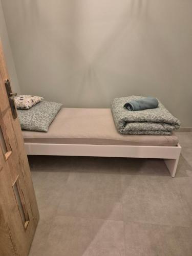 two beds with blankets and pillows on them in a room at Apartament Pracowniczy in Mielec