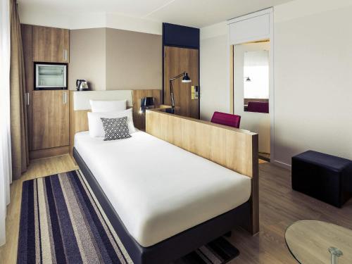 a hotel room with a bed and a desk at Mercure Hotel Nijmegen Centre in Nijmegen