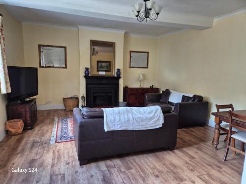 a living room with two couches and a fireplace at Lavender Cottage in Hereford