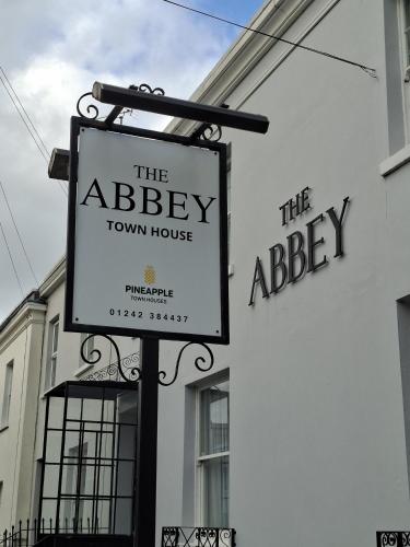 a sign for the abbey town house next to a building at The Abbey Town House in Cheltenham
