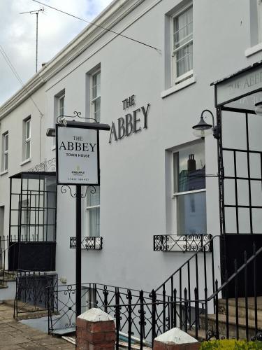 a white building with a sign in front of it at The Abbey Town House in Cheltenham