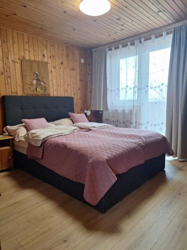 a bedroom with a large bed with pink sheets at Agroturism Jures in Ljutomer