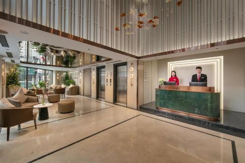 a lobby with two people standing at a reception desk at Hong Ngoc Cochinchine Boutique Hotel & Spa in Hanoi