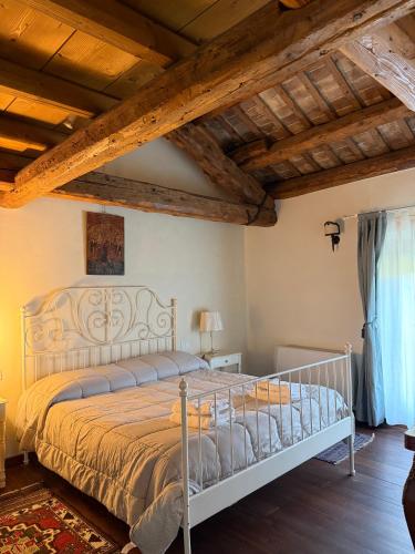 a bedroom with a bed in a room with wooden ceilings at Agriturismo Villa Anconetta in Loreo