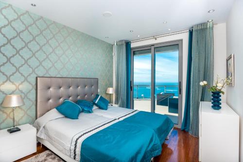 Un dormitorio con una cama grande con vista al mar. en Villa São Lourenço, en Fajã da Ovelha