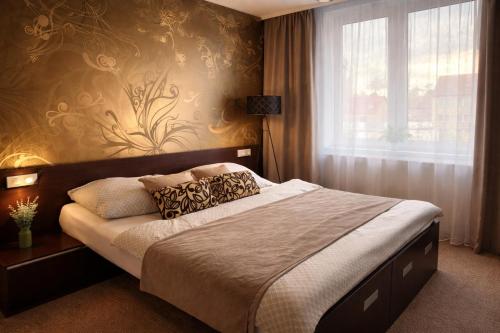 a bedroom with a bed and a window at Apartmány Rosijo in Lednice