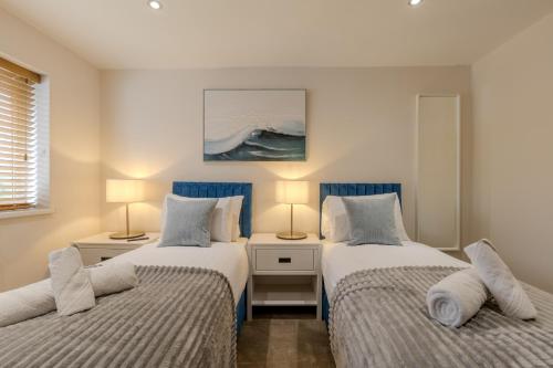 two beds in a room with two lamps at Newhaven in Telford