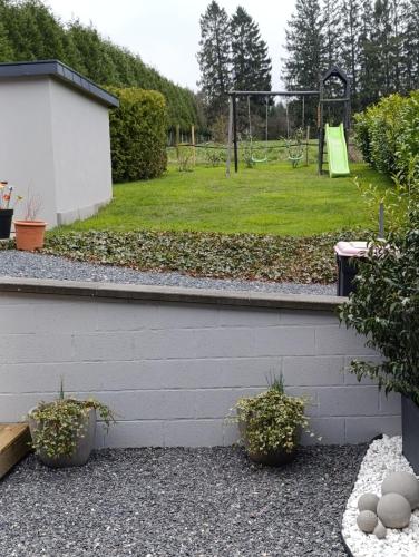 a garden with a playground and a park at Au Coin du Bois in Manhay