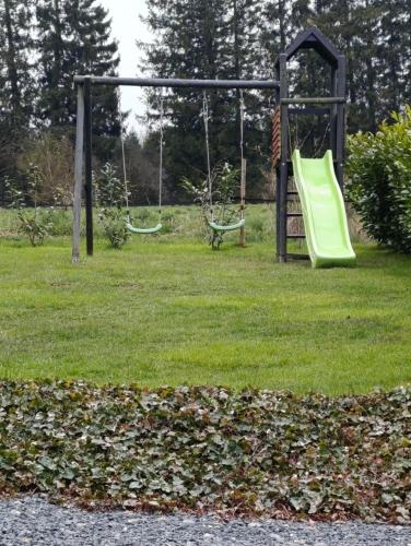 a playground with two swings in a park at Au Coin du Bois in Manhay