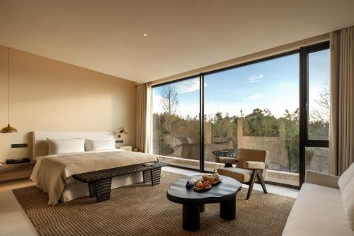 a bedroom with a bed and a large window at PLAN B00b7ANADOL in Xianning