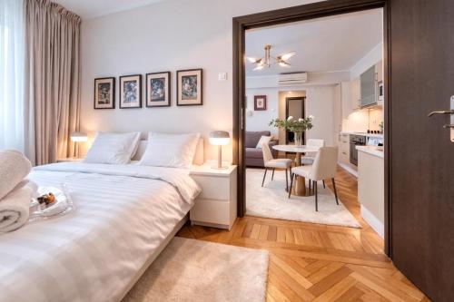 a bedroom with a large bed and a dining room at Victoriei Boutique Apartment in Bucharest