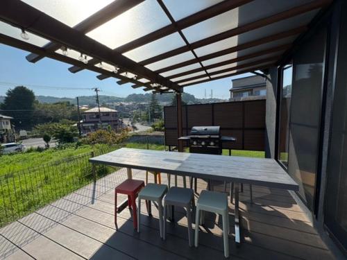 a table and chairs on a patio with a view at 【BBQ可、送迎あり】Nonbiri Slowly Ocean in Oiso