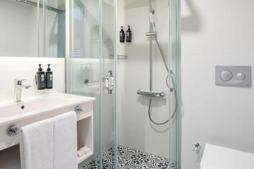 a white bathroom with a shower and a sink at Ramada by Wyndham Dalaman in Dalaman
