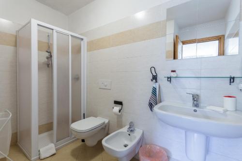 a white bathroom with a sink and a toilet at B&b CASCINA CORNELLA in Cremeno