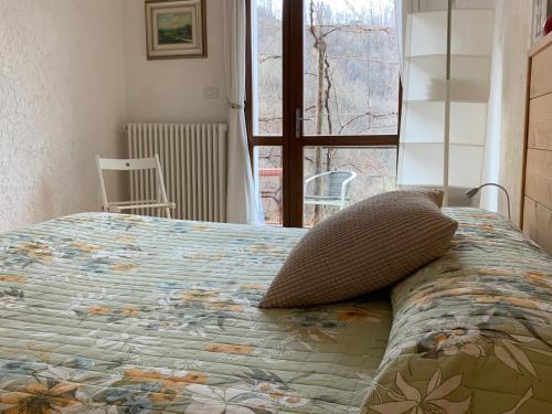 a bed with a pillow on it in a bedroom at B&b CASCINA CORNELLA in Cremeno
