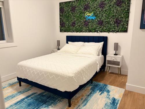 a bed in a bedroom with a painting on the wall at Elevated Horizon Retreat in Chilliwack