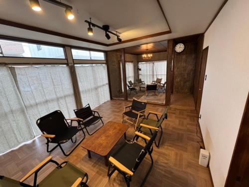a room with chairs and a table and a clock at 『貸切、BBQ 可、送迎あり』Nonbiri Slowly Plant in Oiso