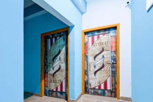 two doors with stained glass panels on a building at Hotel O Blue Valley in Khandagiri