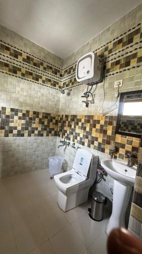 a bathroom with a toilet and a sink at Hotel Heritage in Kaza