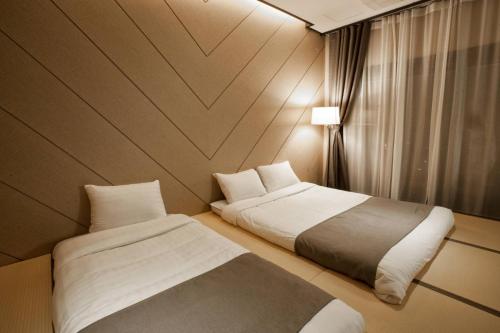 a hotel room with two beds and a window at CS Premier Hotel in Anyang
