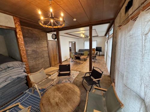 a room with a table and chairs and a bedroom at 『貸切、BBQ 可、送迎あり』Nonbiri Slowly Plant in Oiso