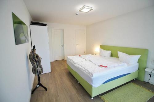 a bedroom with a green and white bed in a room at Golfresidenz D 0 06 in Grömitz