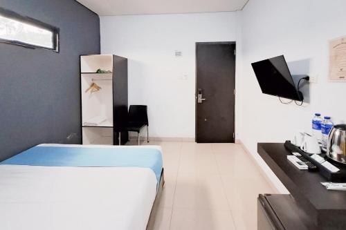 a bedroom with a bed and a television in a room at SANS Stay Raja Soeta Hostel Lampung in Hajimana