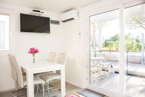 a white dining room with a white table and chairs at Floating house - Marina Relax in Portorož