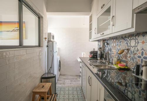 a kitchen with a sink and a refrigerator at BBA Appartement climatisé vue mer Baleal in Ferrel