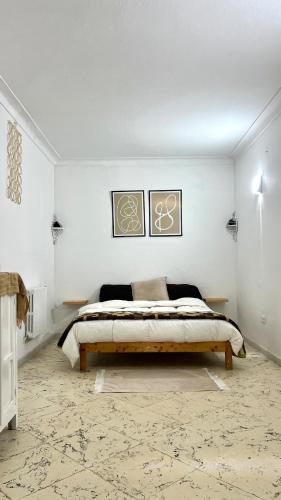 a bedroom with a bed in a white room at Little apartment in Hammamet